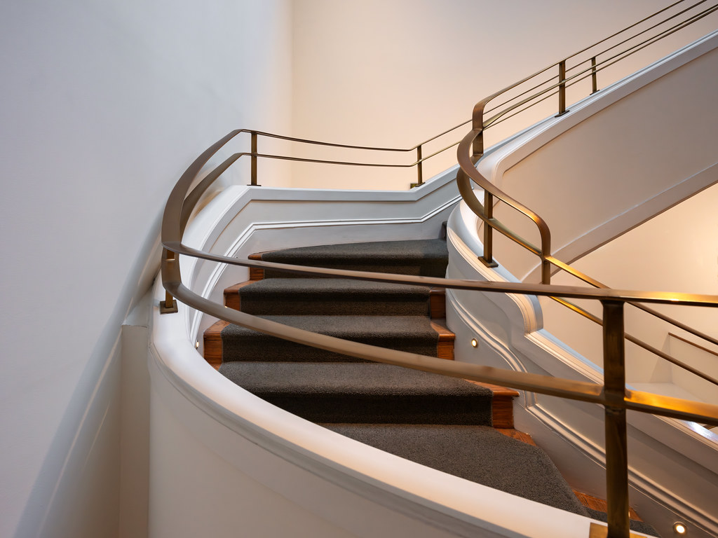 Curved staircase with polished brass handrails
