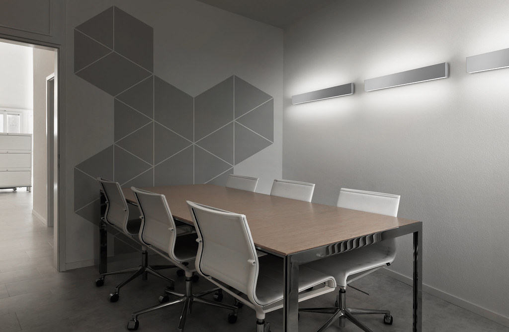Modern meeting room with a conference table and a geometric wall pattern